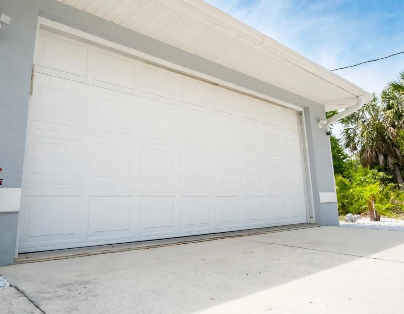 White short-panel double garage door installed on a Las Vegas home with a clear desert sky
