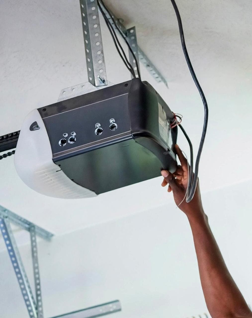 GRC Garage Doors technician servicing a ceiling-mounted chain-drive garage door opener