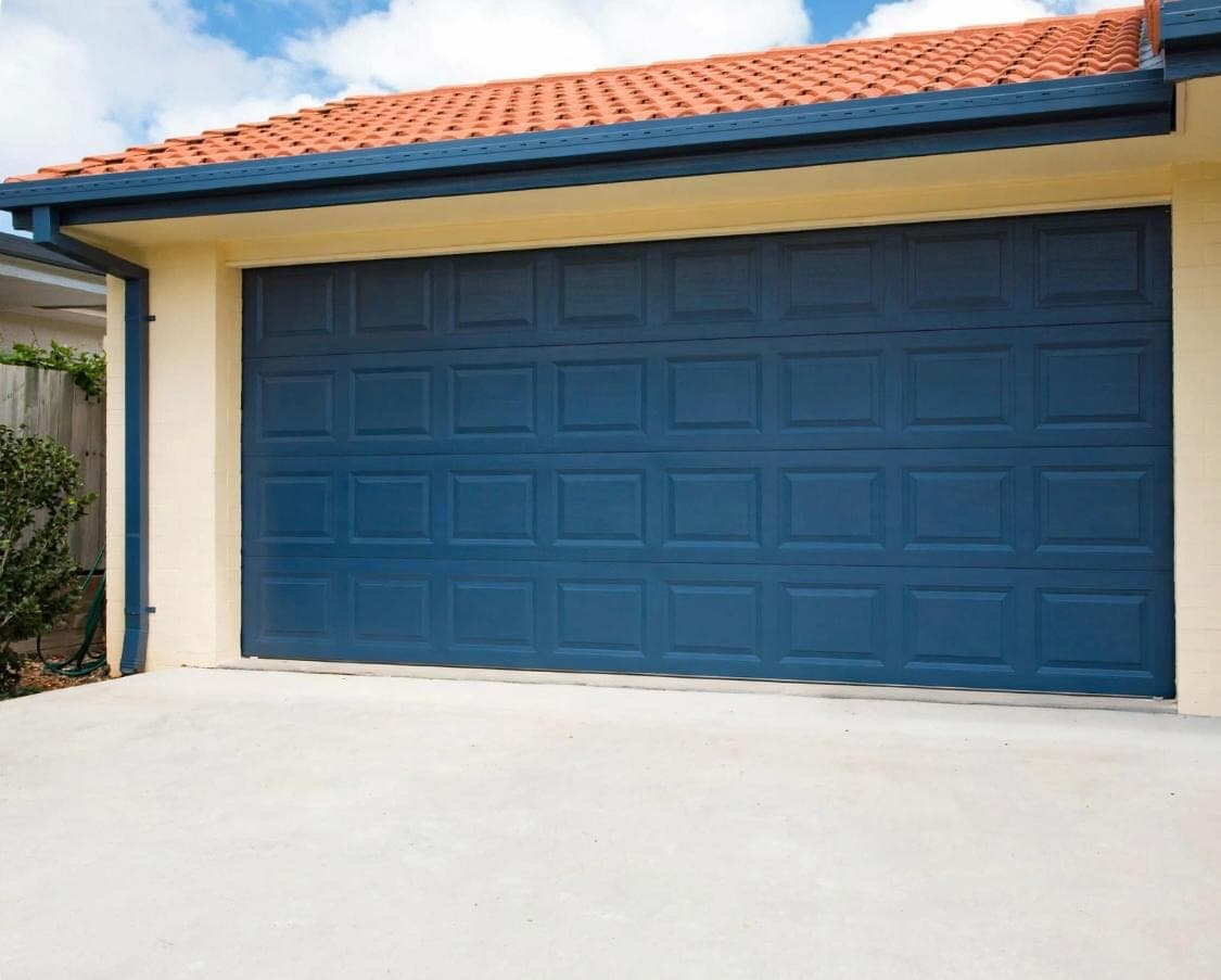 Navy blue raised-panel double garage door on a tile-roof Las Vegas home